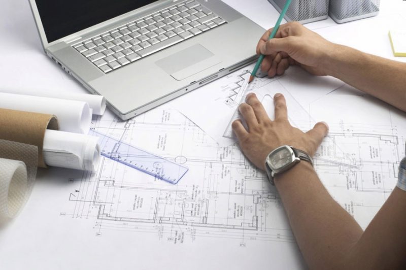 Mujer señalando un plano de construcción